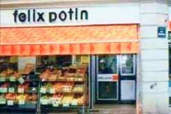 Vitrine de la boutique Félix Potin avec une marquise orange et des produits exposés en vitrine.