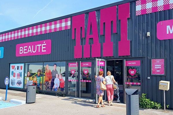 Magasin Tati avec une façade moderne et l'enseigne rose vif "TATI" et la mention "BEAUTÉ".