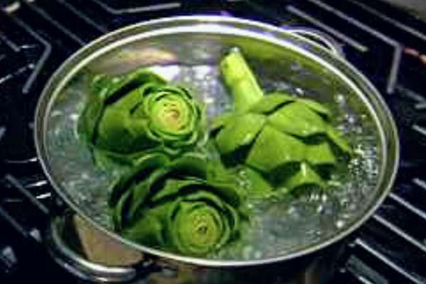 Artichauts à l'étape initiale de cuisson, l'eau commençant à s'imprégner de leurs bienfaits.