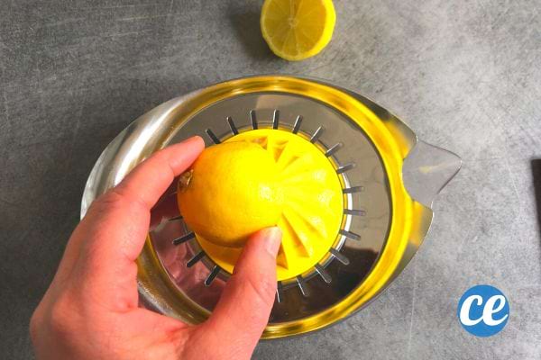 Citron pressé sur un presse-agrume jaune, préparation pour le nettoyage du micro-ondes.