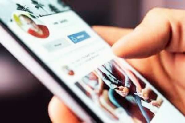 une personne sur son t&eacute;l&eacute;phone qui veut savoir qui regarde son profil Facebook