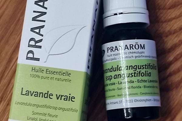 Bouteille d'huile essentielle de lavande à côté de son emballage.