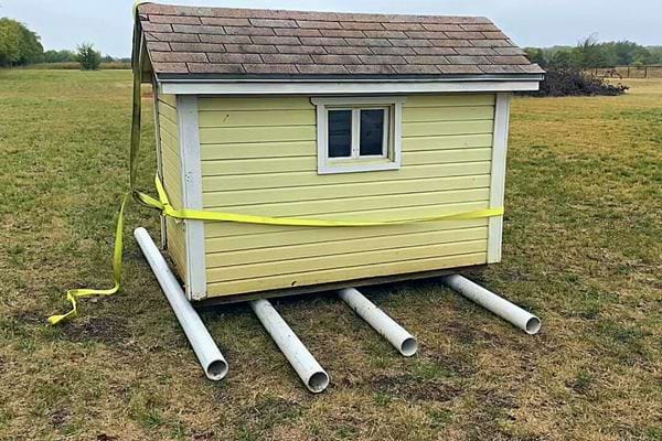 Maisonnette sur des rouleaux PVC jaunes pour la déplacer aisément sur l'herbe.