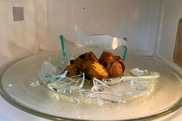 Intérieur micro-ondes, plat en verre cassé, pommes de terre.