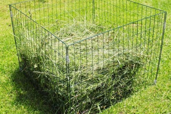 bac de compost simple fabriqué avec du grillage sur une pelouse