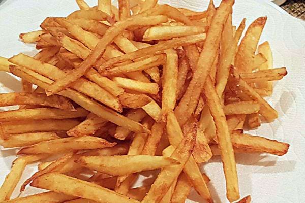 Frites sur papier absorbant blanc.