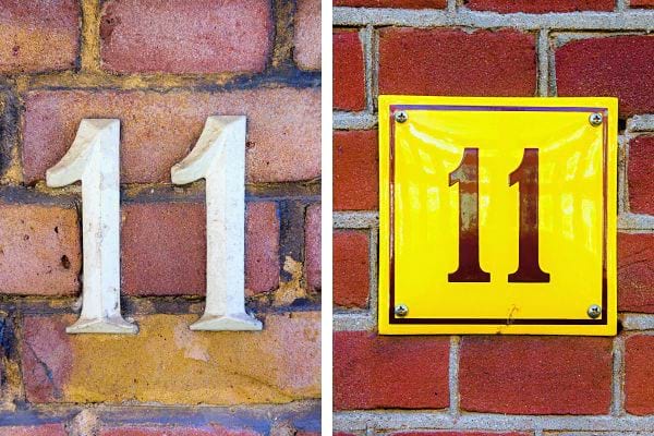 Numéro "11" en relief sur mur de briques, gauche blanc cassé, droite sur plaque jaune.