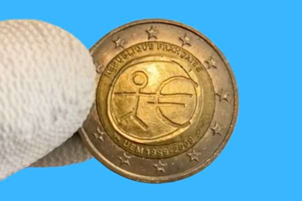 Pièce de 2 euros irlandaise commémorant les 10 ans de l'UEM avec une figure stylisée.