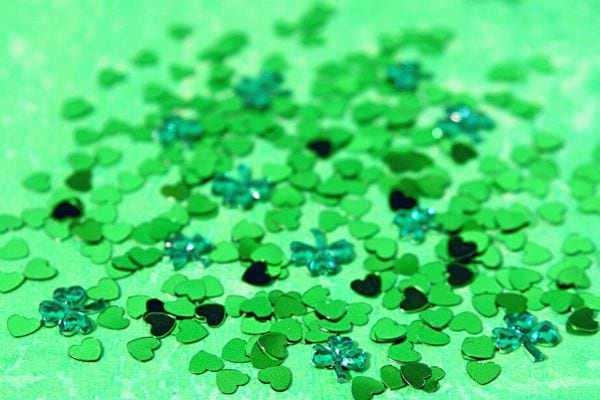 Multiples cœurs verts en paillettes, suggérant une célébration joyeuse et festive de l'amour.