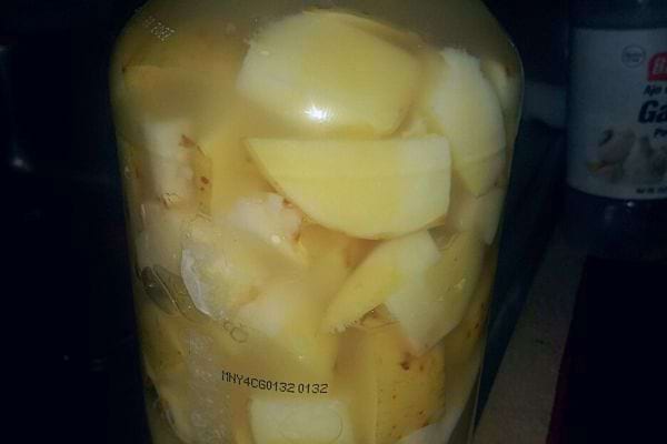 Gros plan sur des pommes de terre pelées dans un bocal en verre.