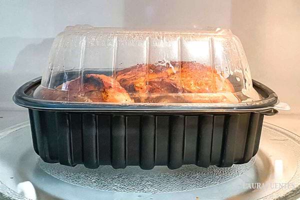 Poulet rôti dans un récipient en plastique au micro-ondes, méthode rapide pour réchauffer.