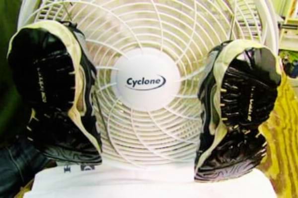 Des baskets qui sèchent devant un ventilateur pour enlever l'humidité et arrêter qu'elles couinent