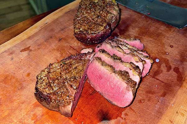 Tranches de gibier poêlées montrant une cuisson rosée.