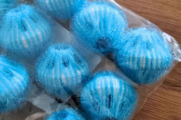 Un paquet de balles bleues conçues pour attraper les poils dans la machine à laver.