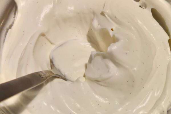 Pot de crème fraîche épaisse avec une cuillère dedans.