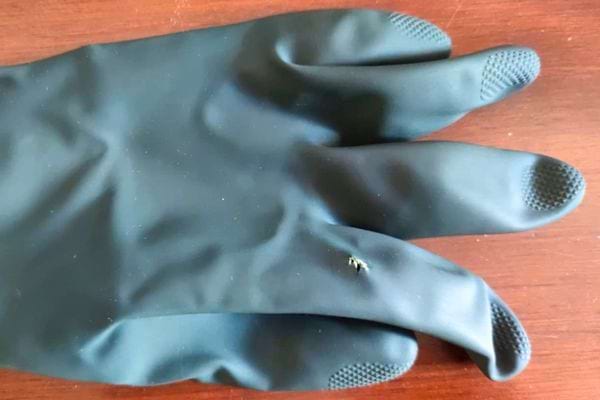 Un gant en latex gris troué