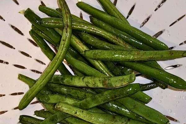 Les haricots verts s'égouttent dans une passoire