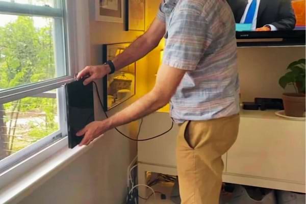 Personne qui installe une antenne TNT intérieure car il n'a pas d'antenne extérieure ni internet