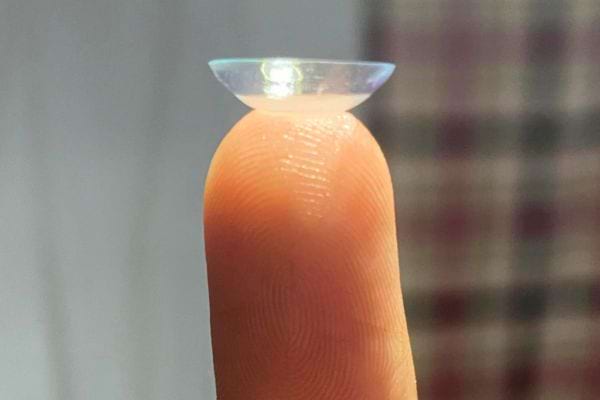 Une lentille de contact sur un doigt.