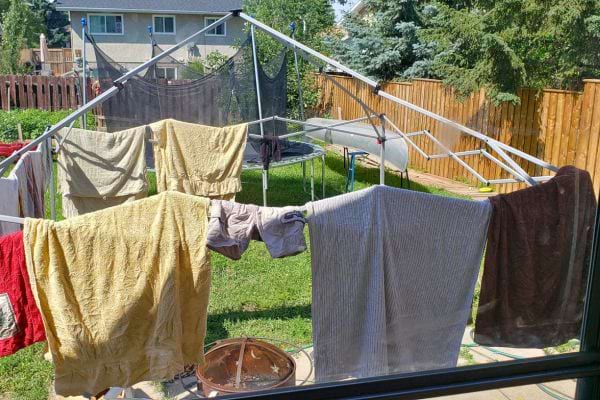 Étendoir extérieur avec vêtements face au soleil, exposition nocturne peut attirer des insectes.