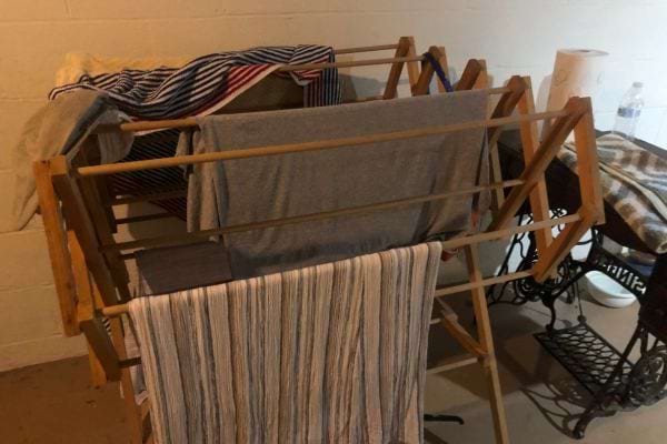 Des vêtements qui sèchent sur un étendoir en bois