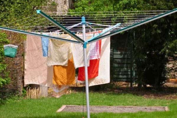 Étendoir rotatif avec linge en plein air, potentiel pour le développement de moisissures nocturnes.