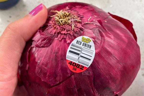 Oignon rouge avec étiquette de supermarché, prêt à être utilisé.