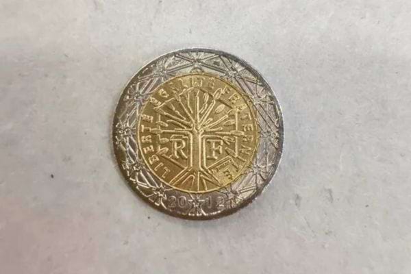 Eine französische 1-Euro-Münze auf einer glatten Oberfläche, Symbol für Glück und Reichtum.
