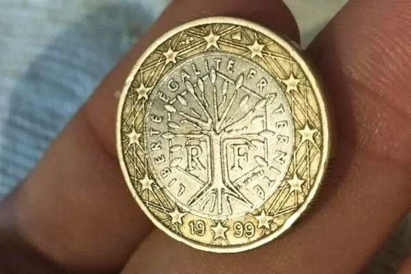 Eine französische 1-Euro-Münze aus dem Jahr 1999, behutsam zwischen den Fingern gehalten, ein Zeichen des Wohlstands.