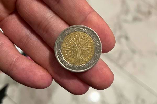 Eine 2-Euro-Münze, die man in der Hand hält, deutet auf eine unerwartete Entdeckung hin.