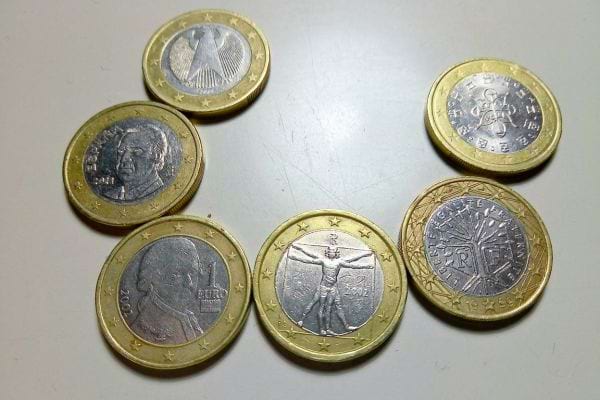 Mehrere auf einer Oberfläche angeordnete Euro-Münzen symbolisieren die gefundene Fülle.