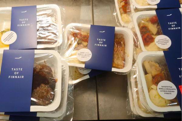 Plusieurs plats d'avion emballés, prêts à être servis.