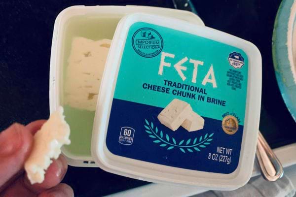 Feta dans un récipient plastique avec du fromage retiré.