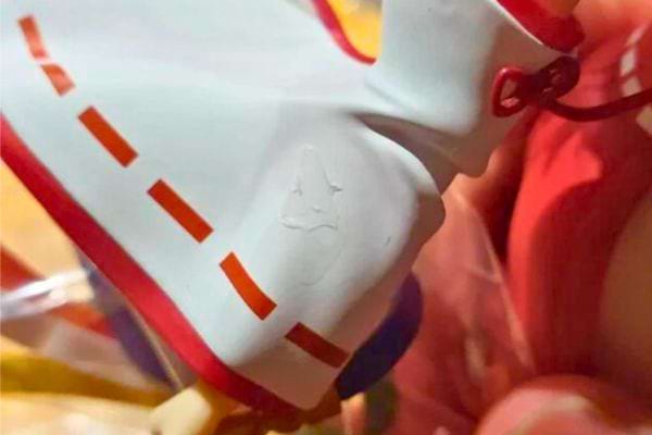 Figurine blanche avec des rayures rouges. Marque de colle sur le plastique.