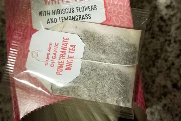 Un sachet de thé "Hibiscus, Strawberry & Raspberry Herbal Tea" près d'une cuvette tachée