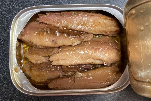 Sardines entières dans une boîte de conserve avec de l'huile.
