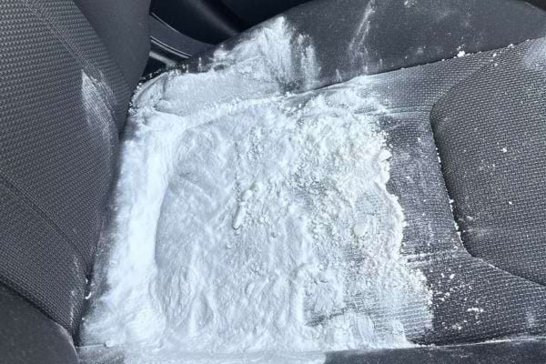 Siège de voiture recouvert de bicarbonate de soude blanc.