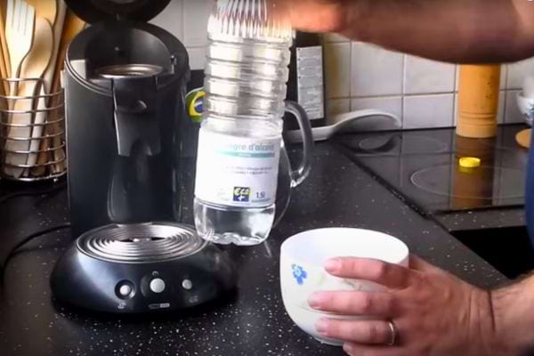 Bouteille de vinaigre d'alcool blanc Conde 10% posée sur une table.