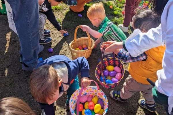 Enfants collectant des œufs de Pâques colorés en extérieur.