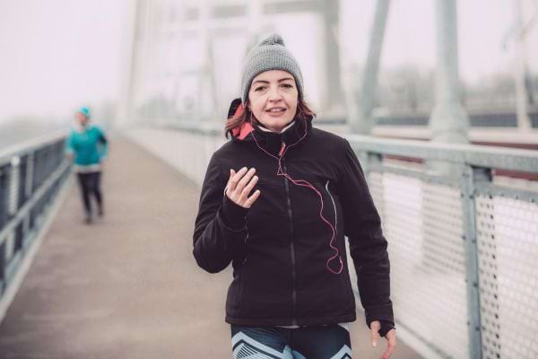 Une femme pratiquant une marche rapide, l'exercice aidant à réguler le transit.