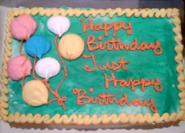 Un gâteau rectangulaire avec un glaçage vert et des ballons colorés.