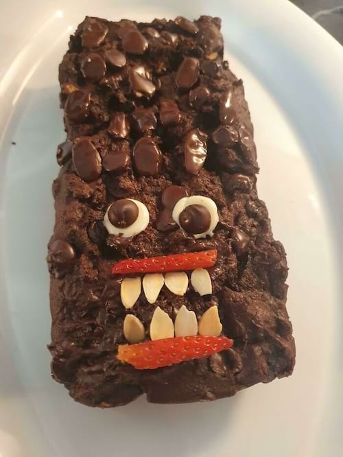 Brownie décoré pour ressembler à un hérisson avec des yeux en bonbons et des dents en amandes.