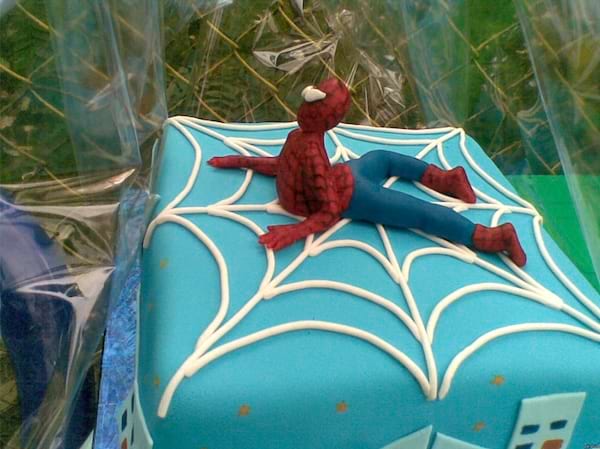 Gâteau carré bleu avec une figurine de Spider-Man dessus.