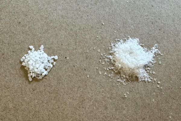 Deux tas de gros sel sur un tapis, un plus gros et un éparpillé.