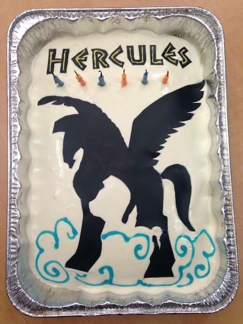 Gâteau avec une silhouette noire de Pégase et le mot "HERCULES" sur le dessus.