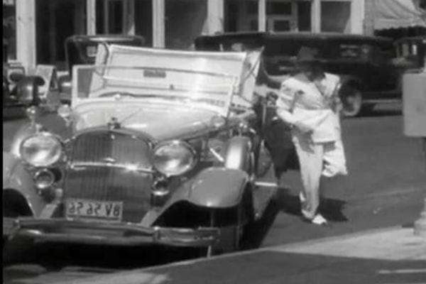 Scène de rue des années 30 avec voiture ancienne