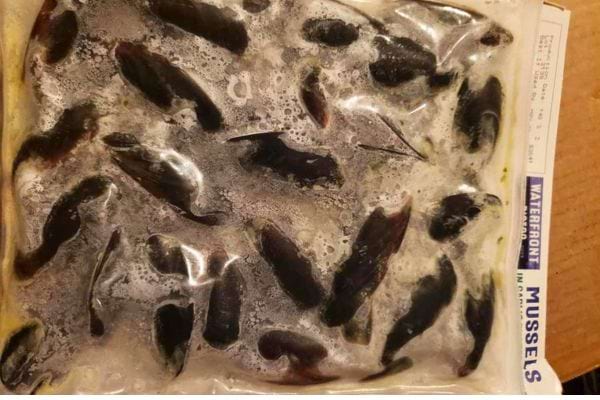 Paquet sous vide de moules congelées, visibles à travers le plastique.