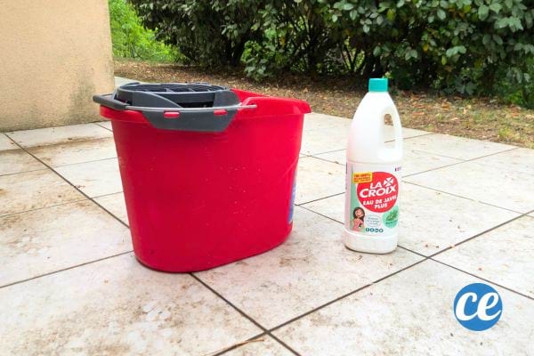 une bouteille d'eau de javel pour nettoyer une terrasse en carrelage