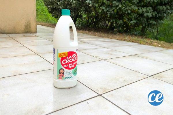 une bouteille d'eau de javel sur une terrasse en carrelage propre