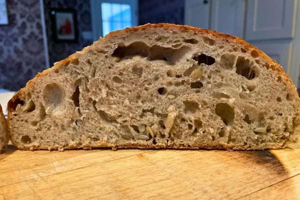 Vue en coupe d'un pain aux grosses alvéoles irrégulières, révélant une texture aérée et humide.